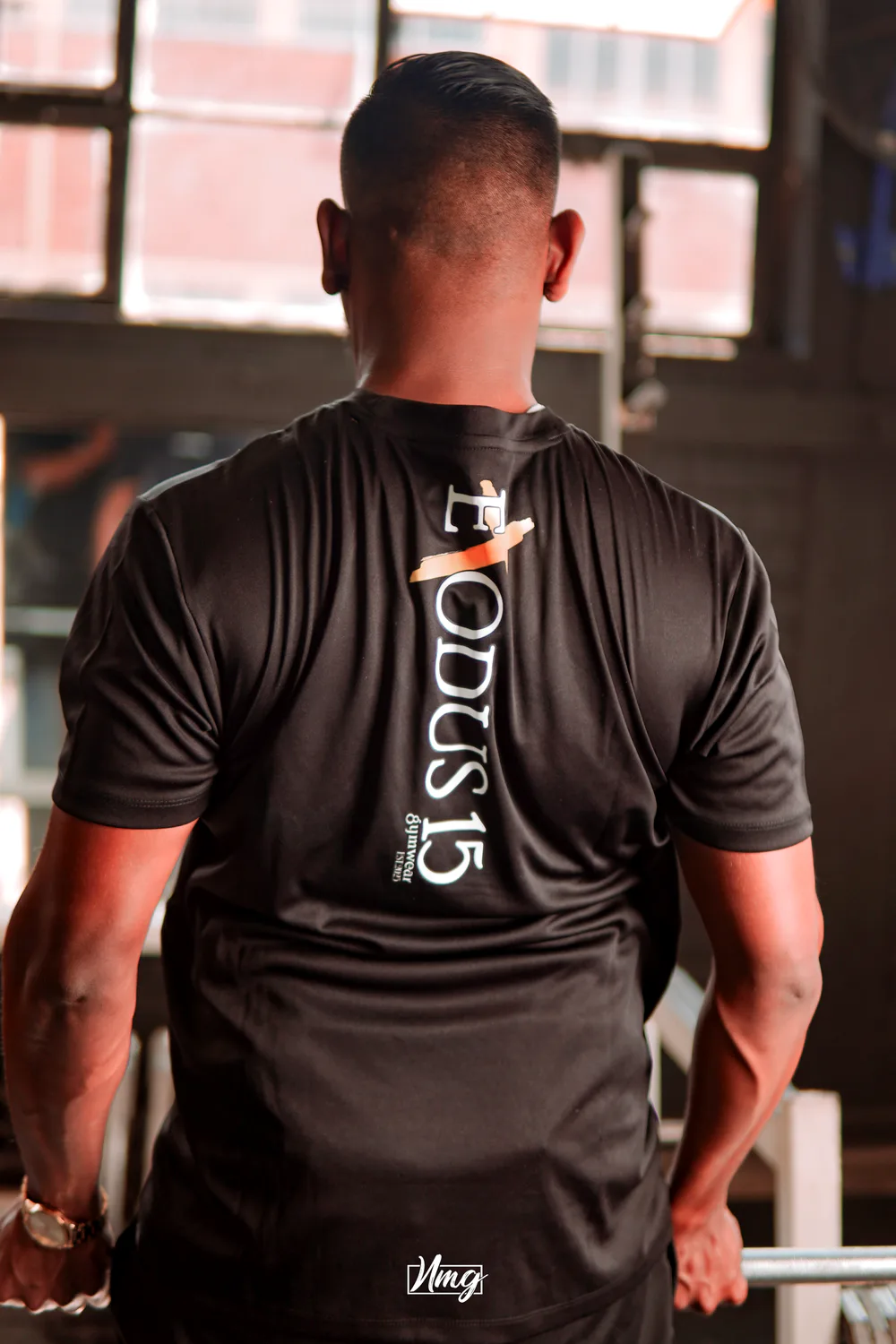 Athlete wearing branded gym apparel, photographed from behind