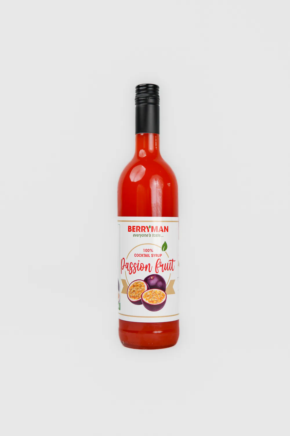 Glass bottle of fruit syrup on white