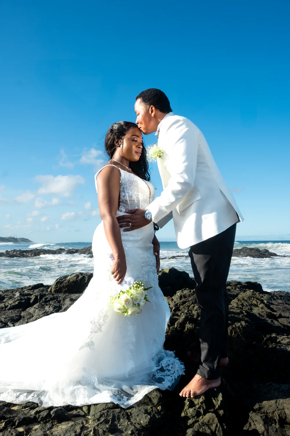 Newlyweds kissing on the beach
